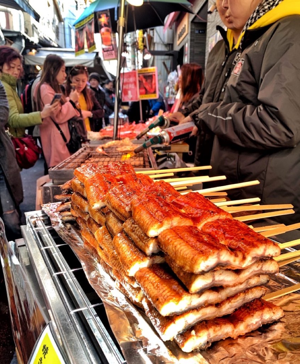 Vendors torch fresh unagi skewers at Tsukiji Outer Market, Tokyo