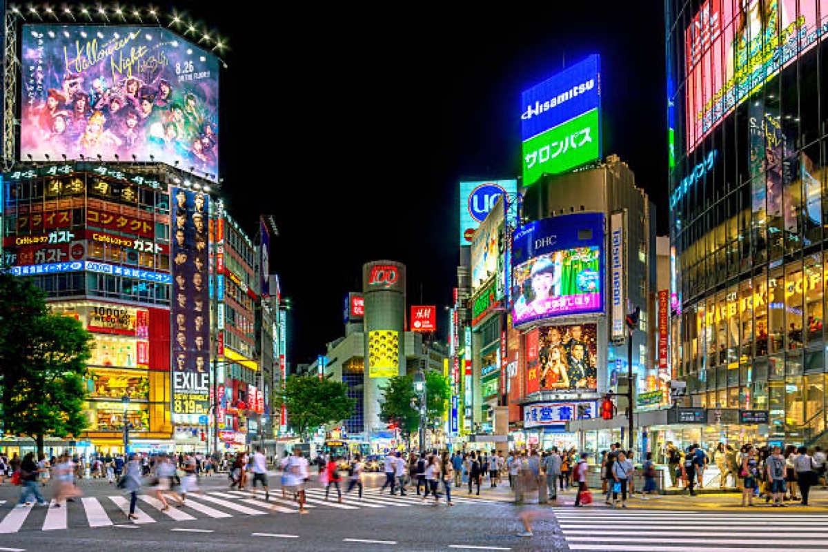 Shibuya Crossing at night with motion-blurred pedestrians and neon lights, Tokyo