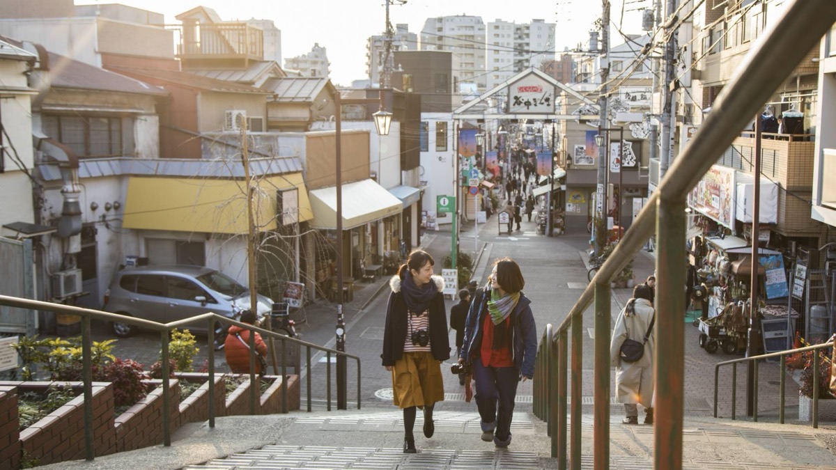Visitors on the Yuyake Dandan steps leading to Yanaka Ginza shopping street at golden hour, Tokyo