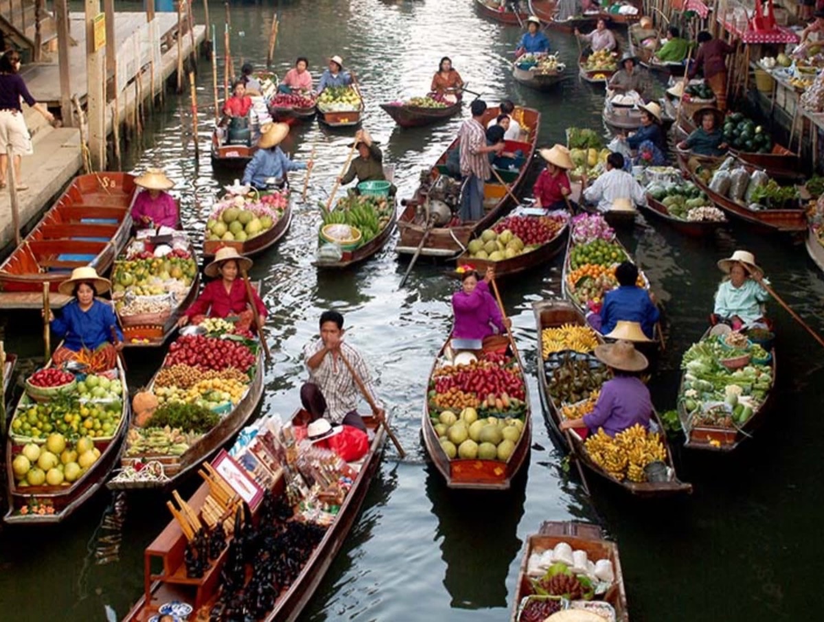 Damnoen Saduak floating market wooden boats loaded with colorful tropical fruits