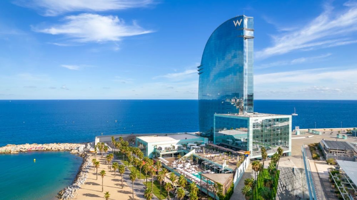 Barceloneta Beach with the W Hotel sail building and crystal-clear turquoise Mediterranean water