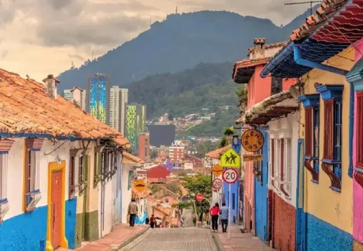 Colorful colonial street in La Candelaria, Bogota, with the Andes mountains in the background