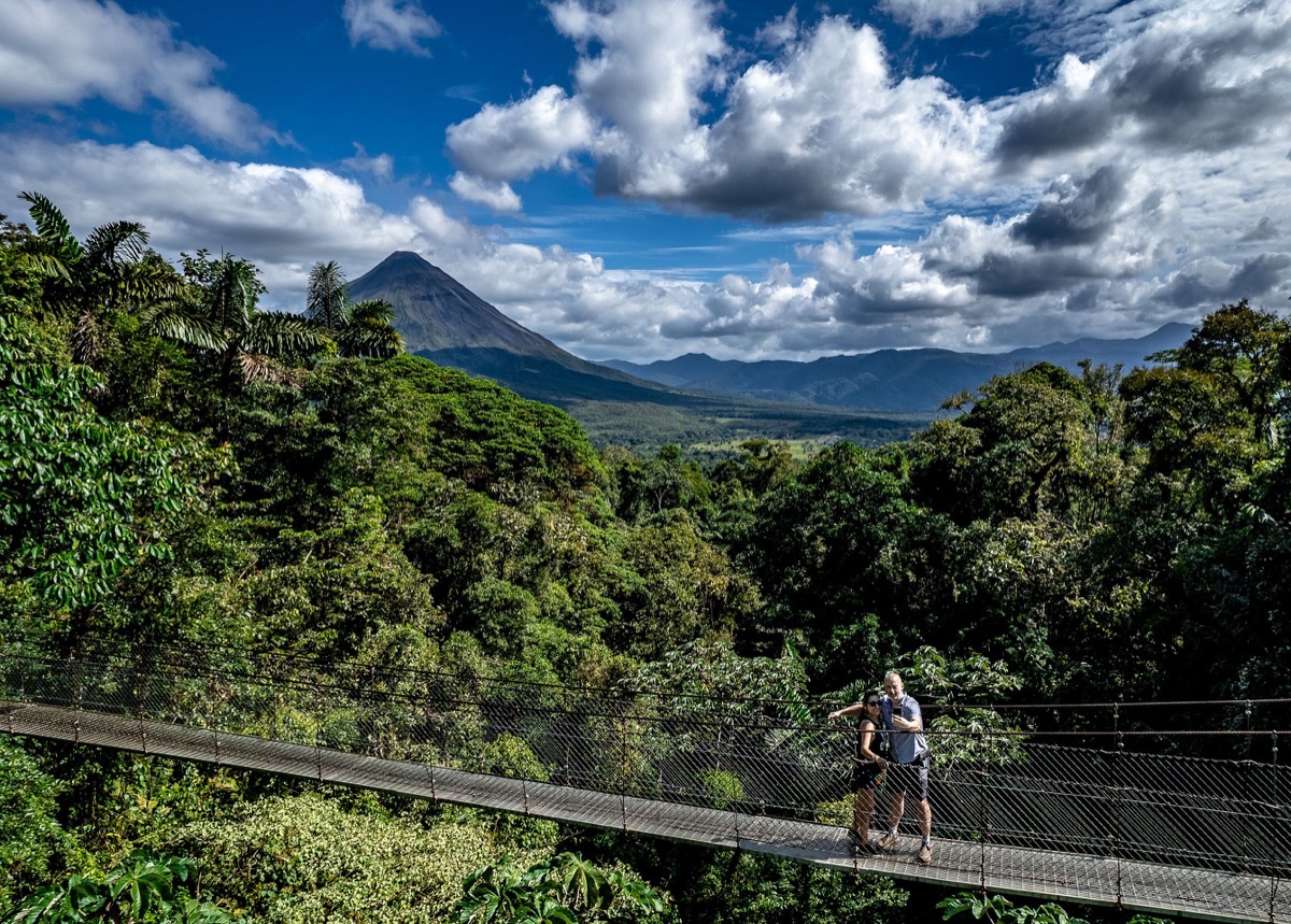 Arenal hanging bridges suspension bridge with Arenal Volcano backdrop and rainforest canopy, Costa Rica