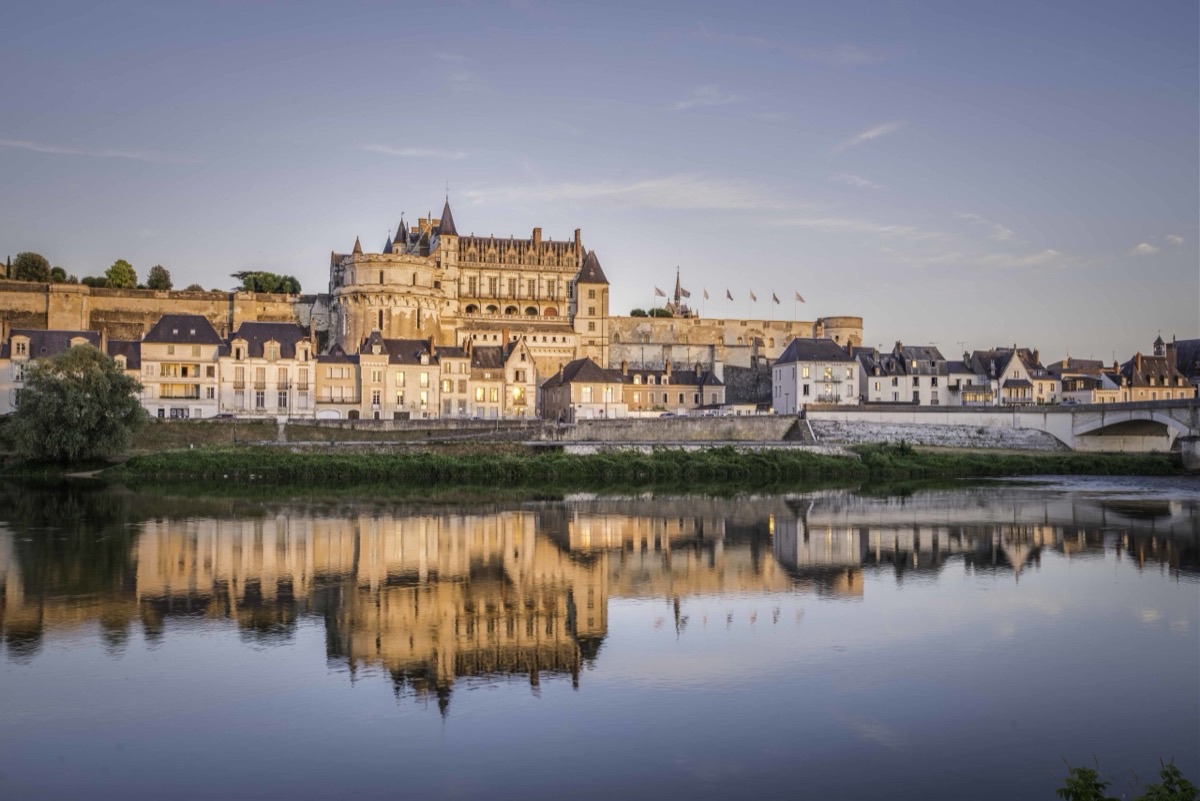 Château d'Amboise at golden hour with Loire River reflection
