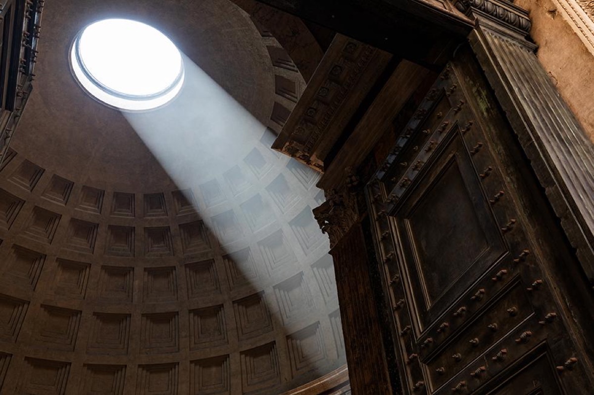 Dramatic light beam through the Pantheon oculus illuminating ancient Rome