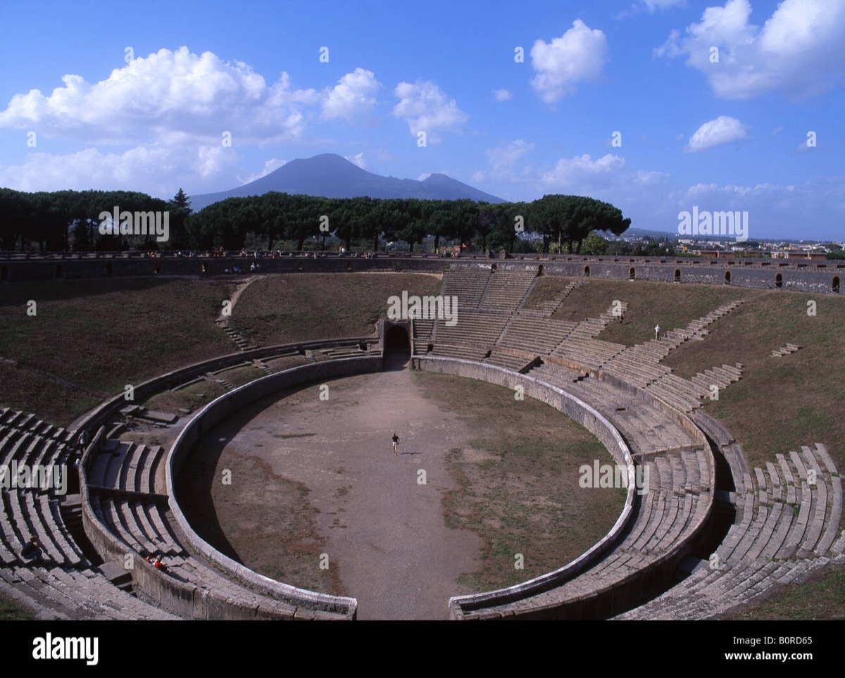 Pompeii's ancient amphitheater ruins with Mount Vesuvius looming in the background