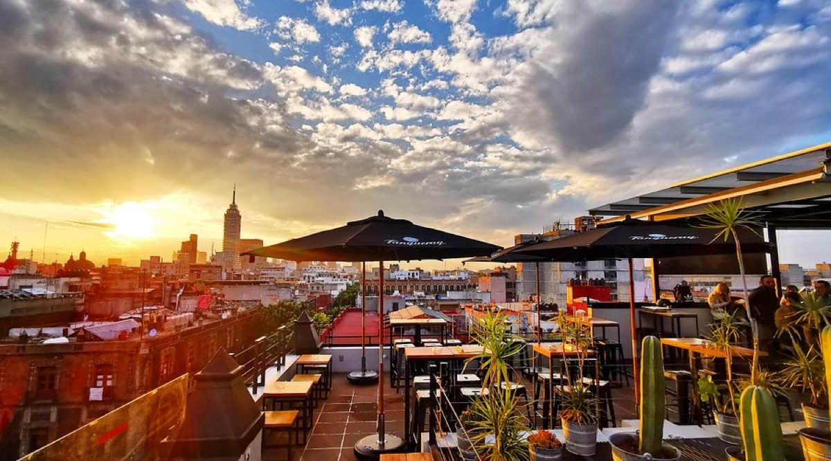 Rooftop bar with cocktails and Mexico City skyline at golden hour