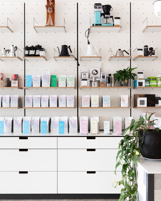 Exchange Specialty Coffee minimalist retail wall with specialty coffee bags and brewing equipment in Adelaide CBD