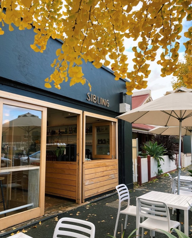 Sibling cafe exterior with golden ginkgo leaves and outdoor seating in Adelaide CBD