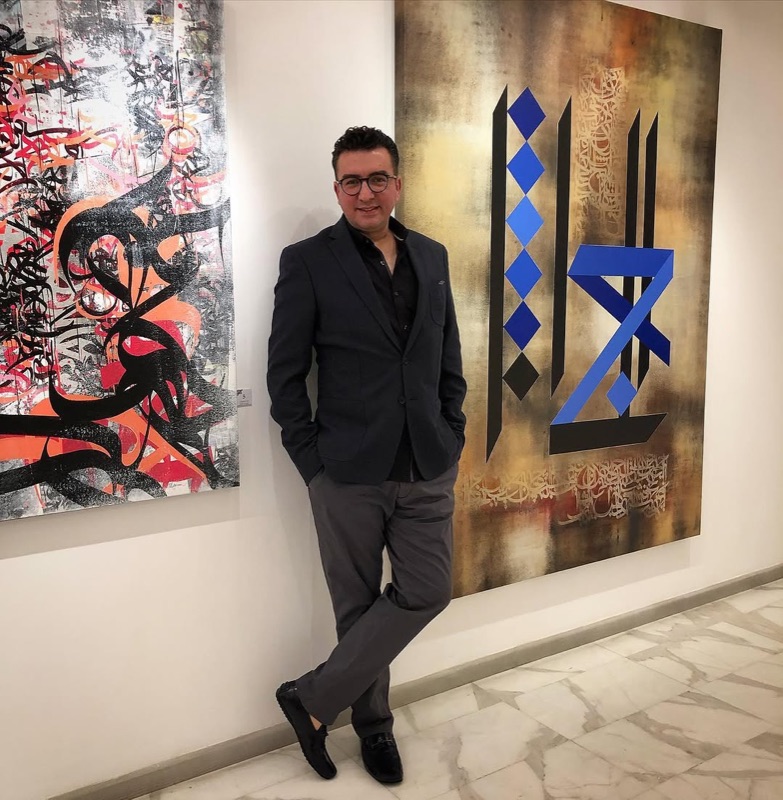 Gallery visitor with Arabic calligraphy artworks at Orient Gallery in Abdali, Amman