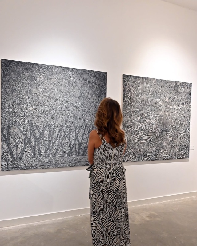 Visitor contemplating black-and-white artworks at Wadi Finan Art Gallery on Abdali Boulevard
