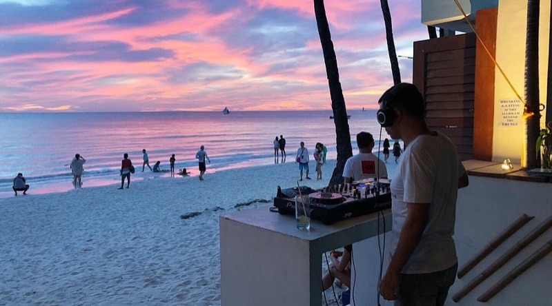 Paraw Beach Club Boracay with sofas on the sand at sunset