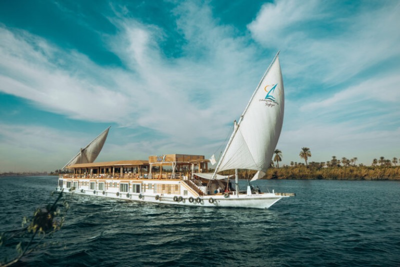 Dahabiya traditional sailing vessel on the Nile near Luxor at sunset