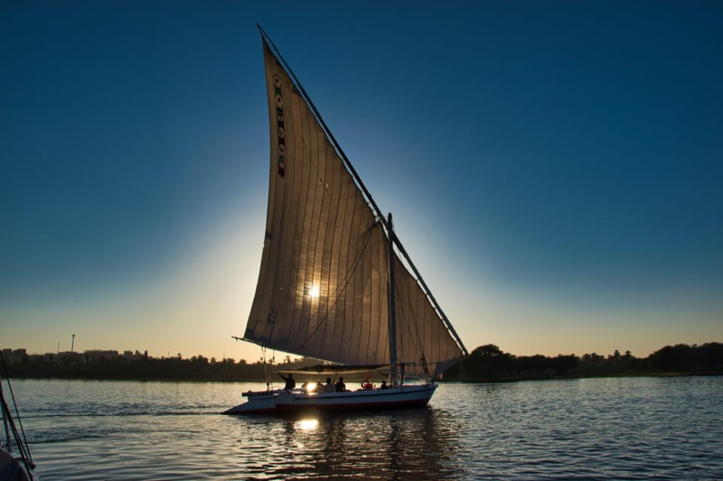 Traditional felucca sailing on the Nile at sunset in Luxor