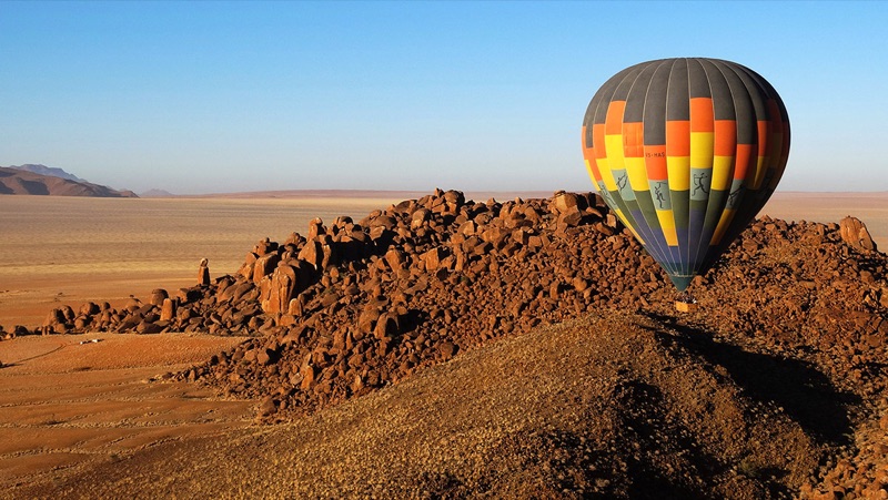 Hot air balloon over NamibRand dunes at dawn